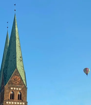 Turn einer Kirche mit zwei Heißluftballons