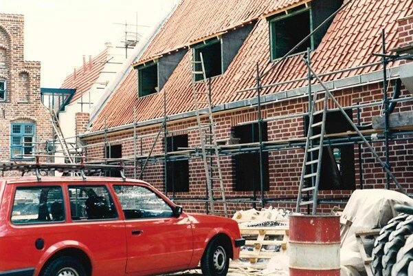Ein Auto vor einem Backsteinhaus, das noch im Bau ist.