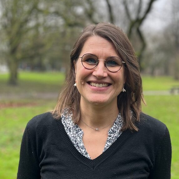 Frau schaut lächelnd in die Kamera