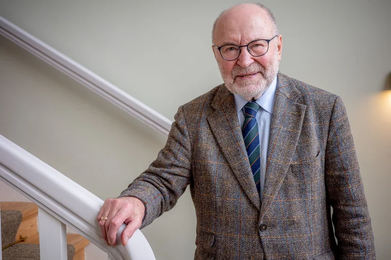 Ein Mann steht an einem Treppengeländer