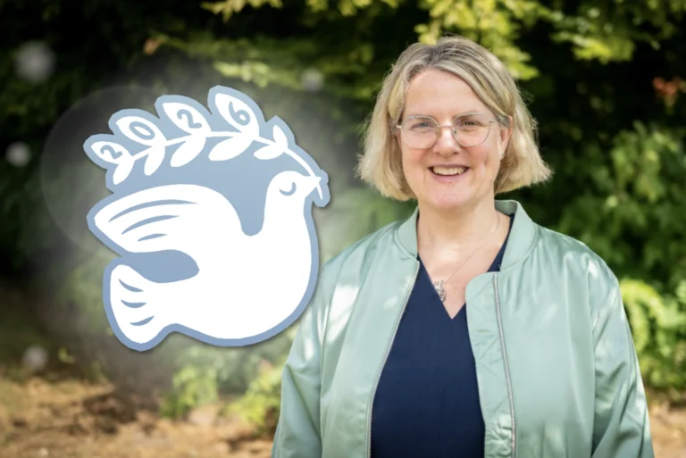 Pastorin Anne Freudenberg-Klopp und die Grafik einer Friedenstaube