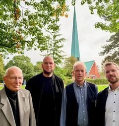 Vier Männer vor einer Kirche