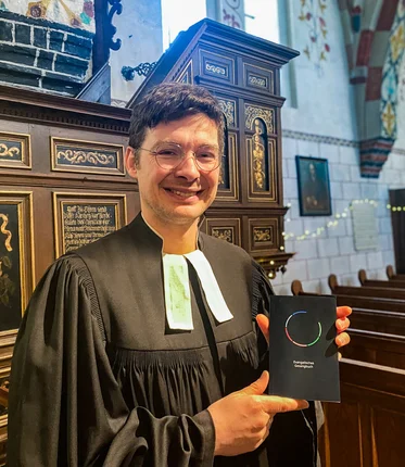 Ein Pastor mit einem Gesangbuch in einer Kirche 