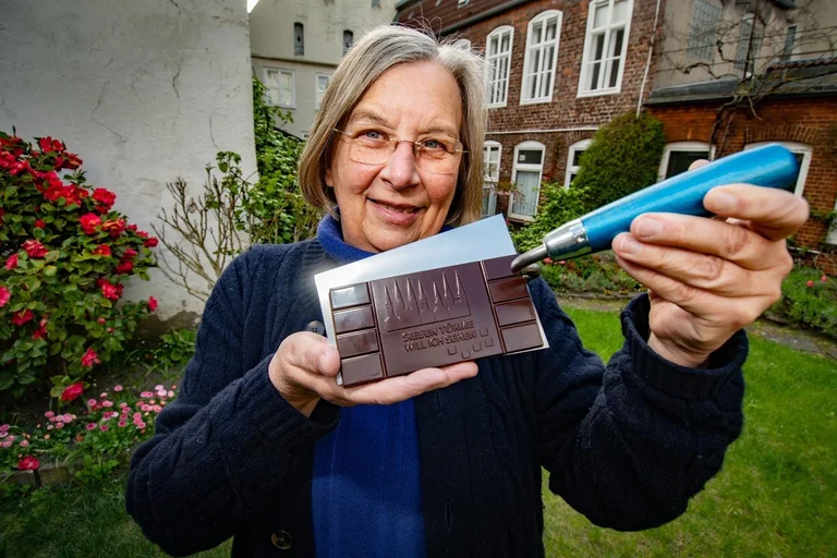 Eine Frau zeigt eine Tafel Schokolade