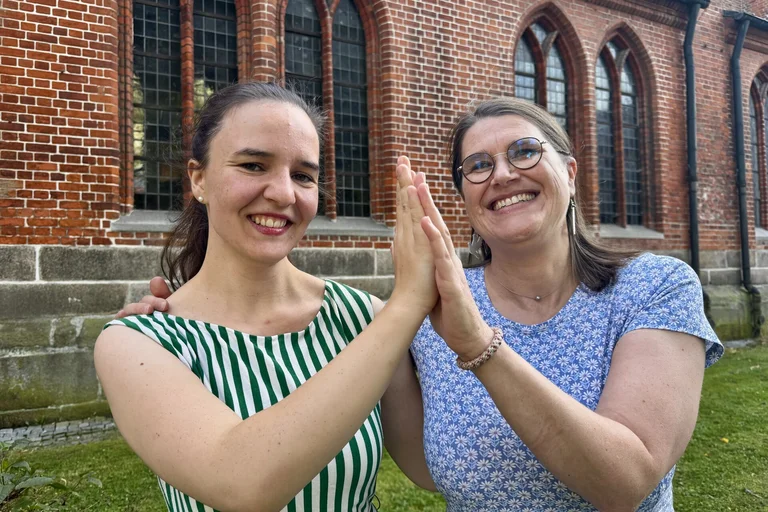 Zwei Frauen vor einer Kirche
