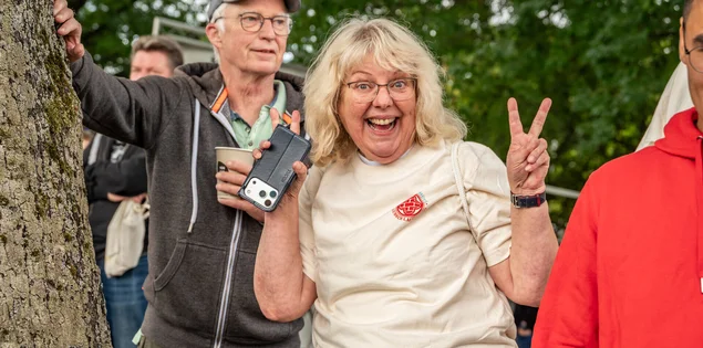 Frau (Susi) feuert vom Ufer die Mannschaft an
