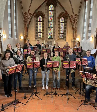 Ein großer Posaunenchor steht in einer Kirche. 
