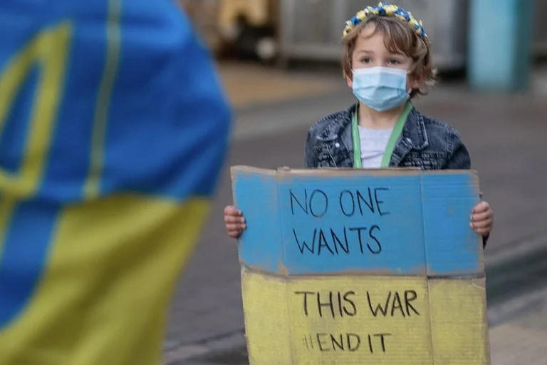 Ein kleines Kind hält ein Solidaritätsplakat für die Ukraine