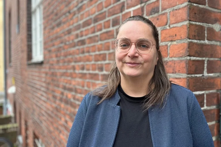 Junge Frau vor einem Backsteingebäude