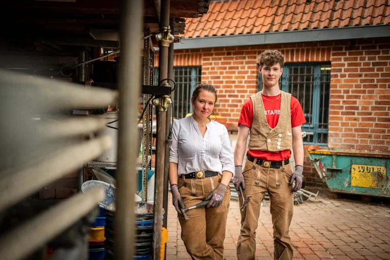 Azubis der Kirchenbauhütte stehen vor gebäude