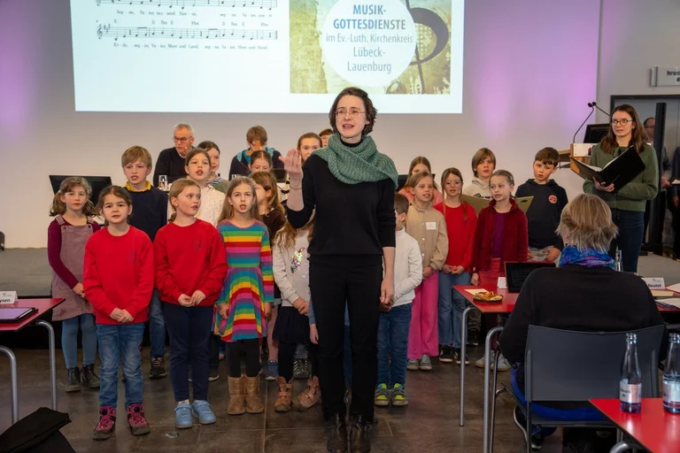Singende Kinder und eine Chorleiterin 