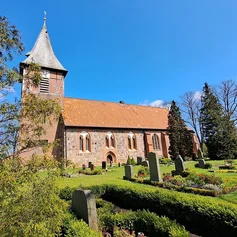 Außenansicht der Marienkirche Büchen-Dorf mit blauem Himmel und  grüner Rasenfläche vor der Kirche