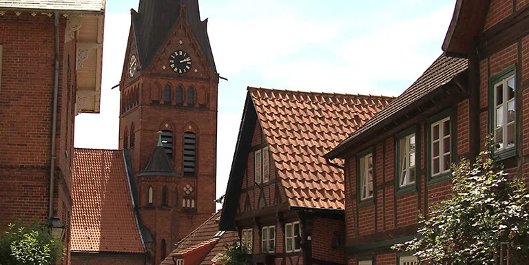 Außenansicht der Maria-Magdalenen-Kirche in Lauenburg mit umliegenden Häusern