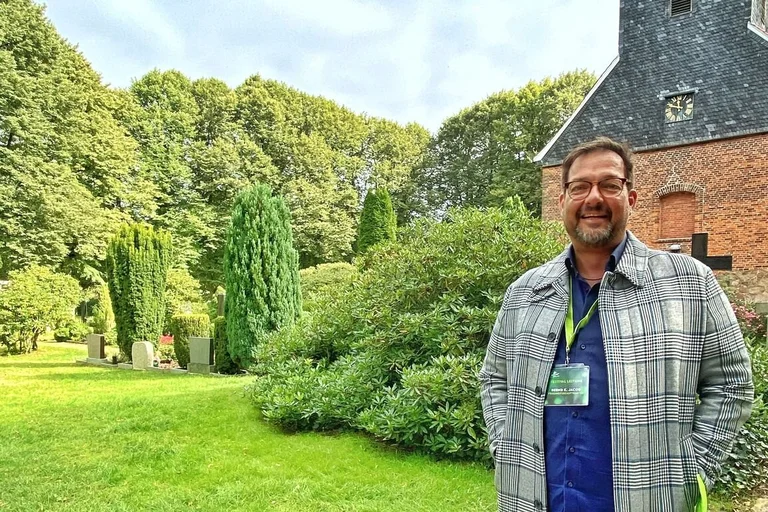 Friedhofsbeauftragter vor der Elisabethkirche in Brunstorf lächelt in die Kamera.