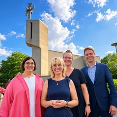 vier Personen vor einer kirche