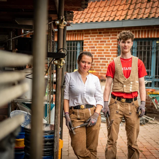 Azubis der Kirchenbauhütte stehen vor gebäude