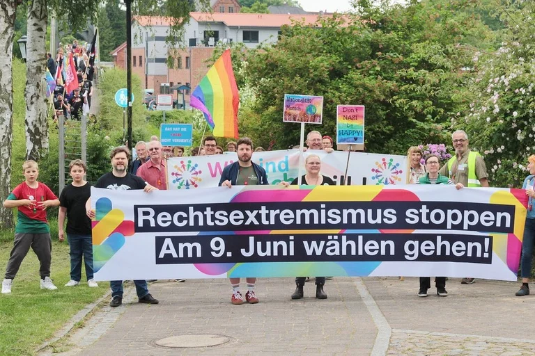 Menschen laufen mit einem Transparent umher