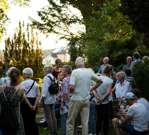 Menschen auf einem Friedhof im Abendlicht