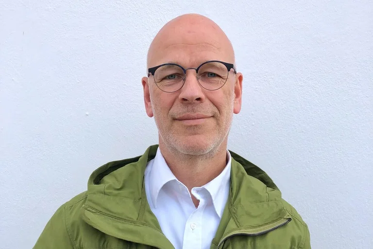 Ein Mann lächelt in die Kamera. 