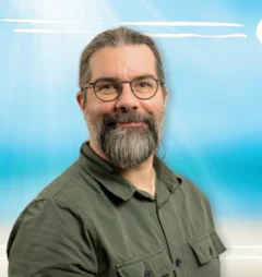 Einn Mann lächelt in die Kamera
