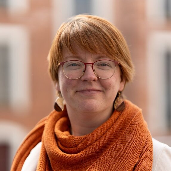 Junge Frau lächelt frontal in die Kamera