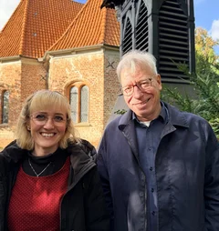 Zwei Menschen stehen vor einer Kirche 