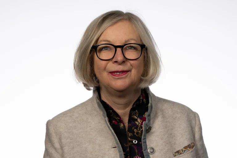 Frau mit Brille lächelt in die Kamera