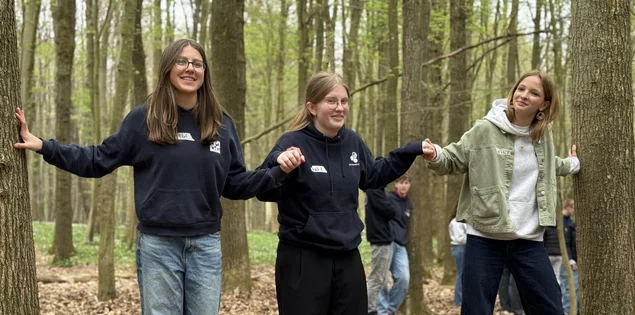 Jugendliche auf einer Slackline im Wald
