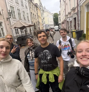 Junge Menschen gucken fröhlich in die Kamera.