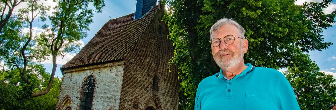 Ein Mann steht vor einer Kapelle