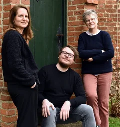 Drei Personen schauen in die Kamera 