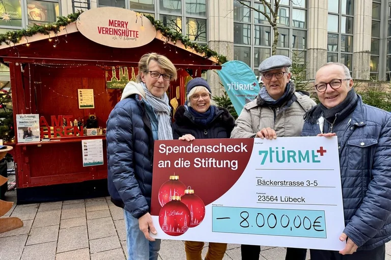 Vier Menschen haltenden einen Scheck fest 