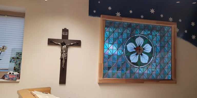 Kapelle von Innen mit Kreuz und buntem Fenster
