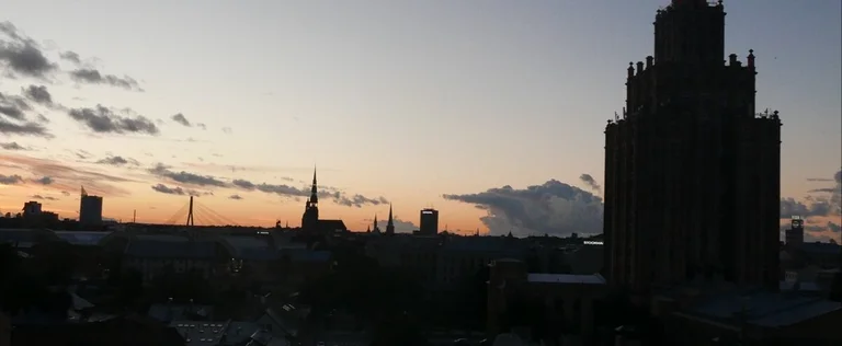 Ein Sonnenuntergang mit Gebäudesilhouetten davor