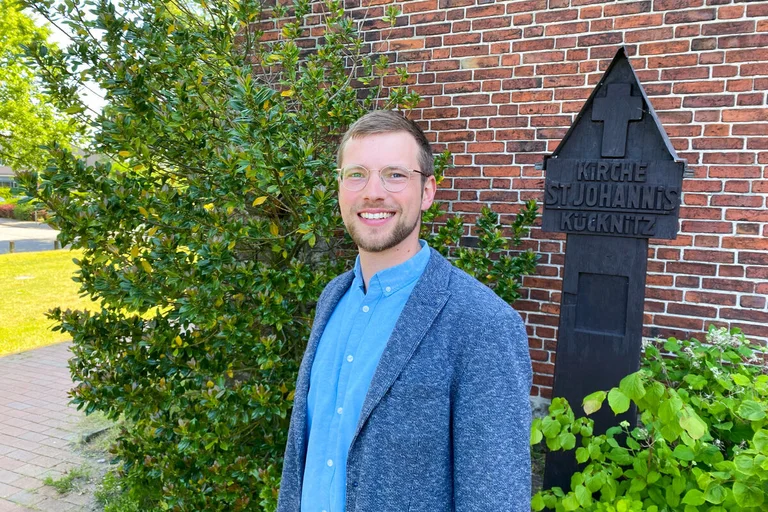 Ein Mann steht vor einer Kirche
