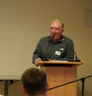 Ein Mann steht an einem Rednerpult. 