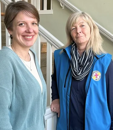 Zwei Frauen stehen vor einer Treppe.