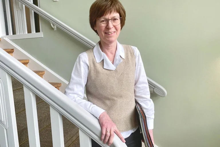 Eine Frau steht an einer Treppe.