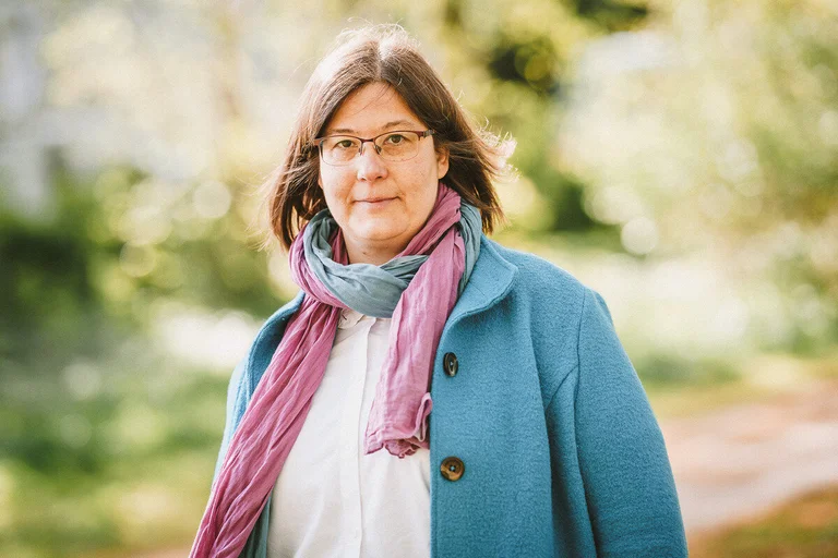 Frau guckt freundlich in die Kamera.