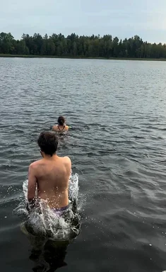 Zwei Menschen von hinten in einem Badesee.