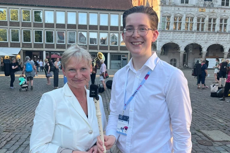 Eine Frau und ein Mann stehen auf einem Marktplatz.