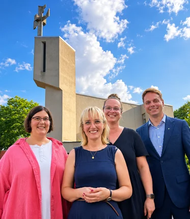 vier Personen vor einer kirche