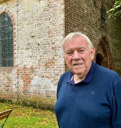 Ein älterer Mann vor einer Kirche