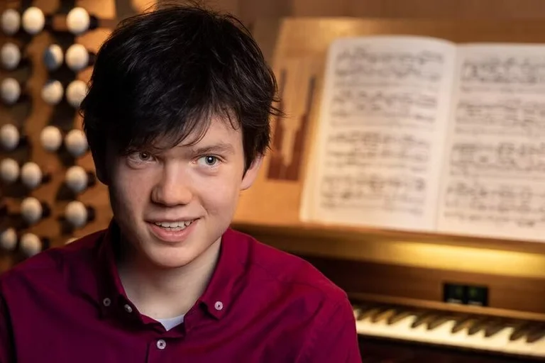 Der junge Organist Julian Emanuel Becker vor dem Spieltisch einer Orgel