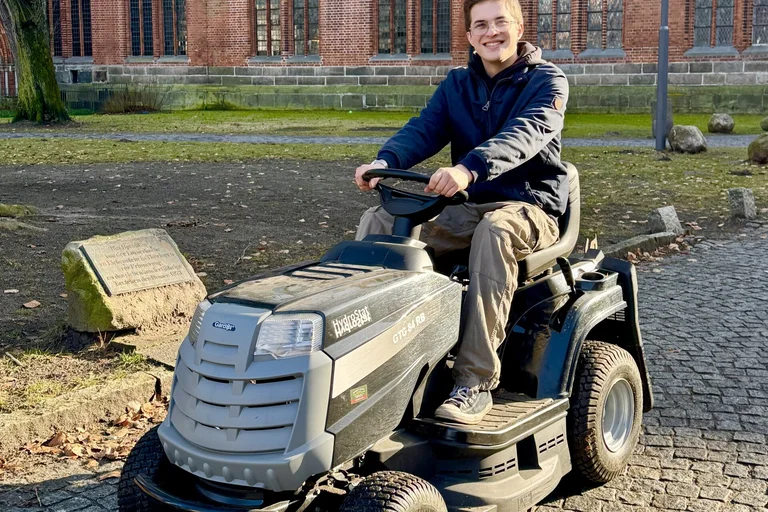 Ein Mann auf einem Rasenmäher