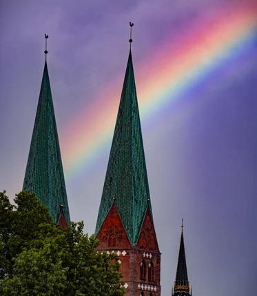 Zwei Kirchtürme mit einem Regenbogen