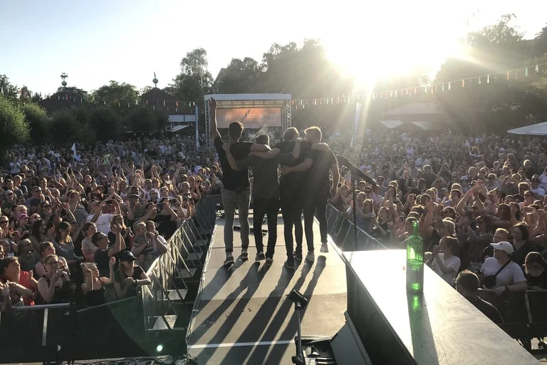 Eine Gruppe vor feiernden Fans im Gegenlicht fotografiert.