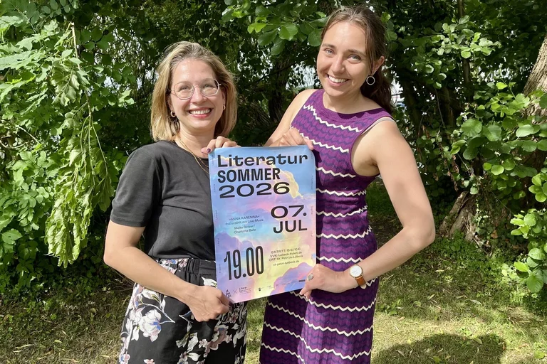 Zwei Frauen halten ein Plakat fest