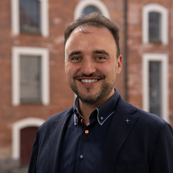 Ein Mann lächelt in die Kamera