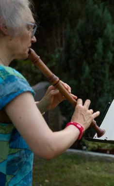 Flöten spielende Frau im Grünen